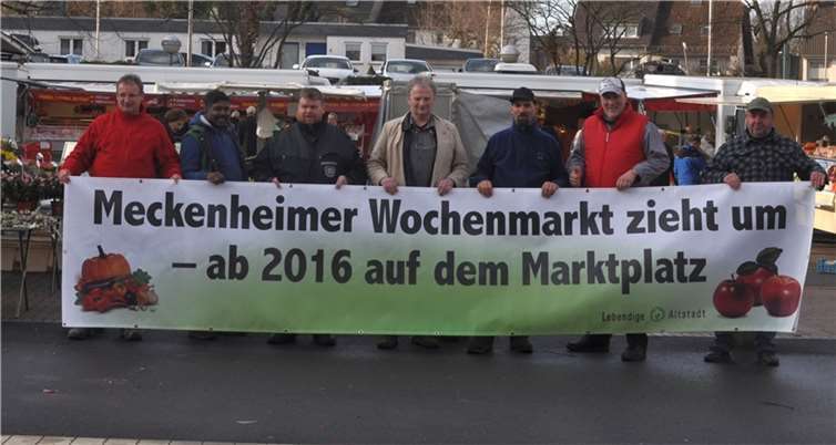 Markthändler und Marktmeister Jörg Begerow weisen auf den Umzug des Meckenheimer Wochenmarktes hin.privat