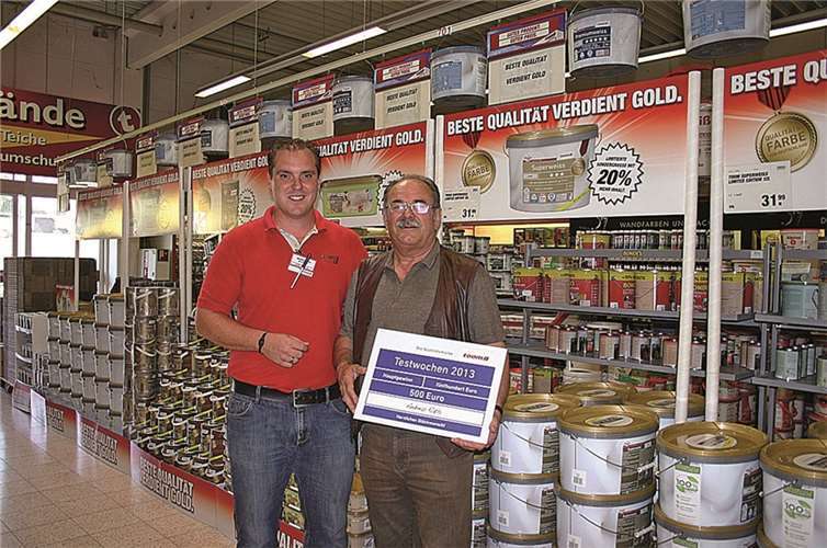 Marktleiter Martin Düwell überreicht dem glücklichen Gewinner Andreas Rath eine symbolische Scheck über 500 Euro. RÜ