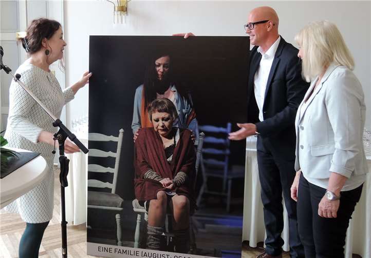 Markus Scherer, Pressesprecher des Theaters, präsentierte das Werbe-Plakat des Stücks „Eine Familie“, in dem Hölbing die starke Rolle der alten Dame spielte.