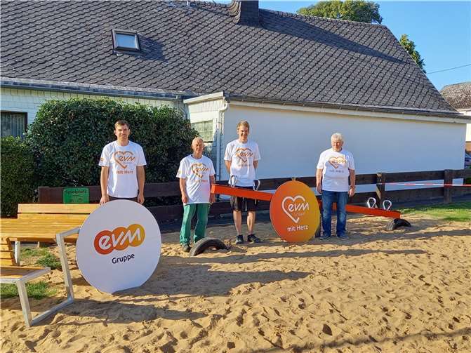 Markus Thiel von der evm-Gruppe mit Gemeindearbeiter Christian Lais, Beigeordnetem Lukas Thiel und Bürgermeister Bodo Weinmann an der neuen Wippe und Sitzgruppe des umgestalteten Spielplatzes in Rückeroth. Foto: evm-Guppe