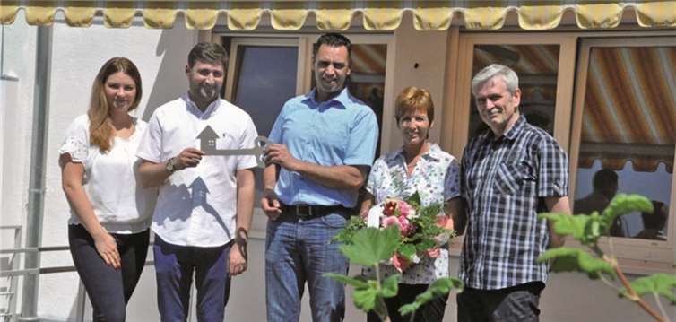 Markus Wahl überreicht an Serkan Karasu den symbolischen Hausschlüssel, die Vorbesitzer einen Blumengruß. AB