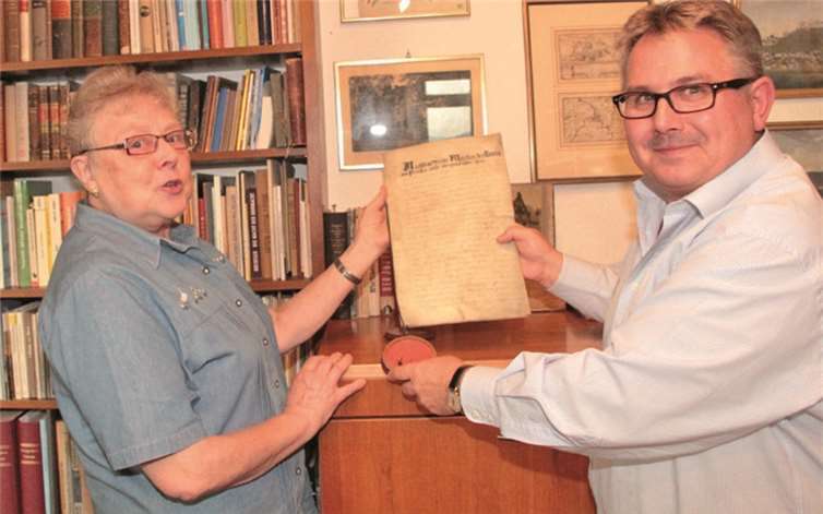 Marlies Huber und Adolf T. Schneider mit einer historischen Stadturkunde.AND