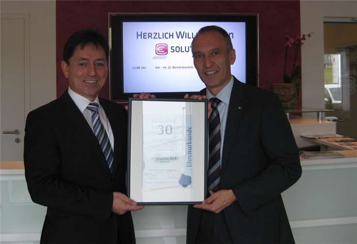 Martin Ellmann (links) freut sich über die Ehrenurkunde der IHK zum 30-jährigen Jubiläum seines Unternehmens.IHK