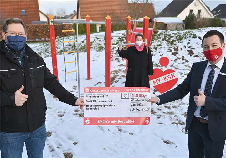 Martin Steinsiek (rechts) als Filialleiter des KSK-BeratungsCenters in Münstermaifeld ließ sich die Gelegenheit nicht nehmen, der Elterninitiative persönlich zur Spende sowie zum gelungenen Sanierungsprojekt zu gratulieren und übergab im Beisein von Bürgermeisterin Claudia Schneider (Mitte) den symbolischen Spendenscheck vor dem neuen Klettergerüst an den Beigeordneten Sven Koch (links). Foto: privat