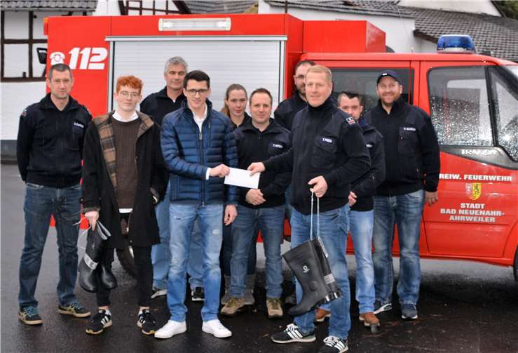 Martin Terporten und Philipp Steinborn (2.und 4.von links) vom Junggesellenverein „St. Martinus“ Heppingen übergaben Stiefel und Scheck im Beisein einiger Feuerwehrkameraden an Heppingens Löschgruppenführer Thomas Preis (3.von rechts). Feuerwehr Heppingen