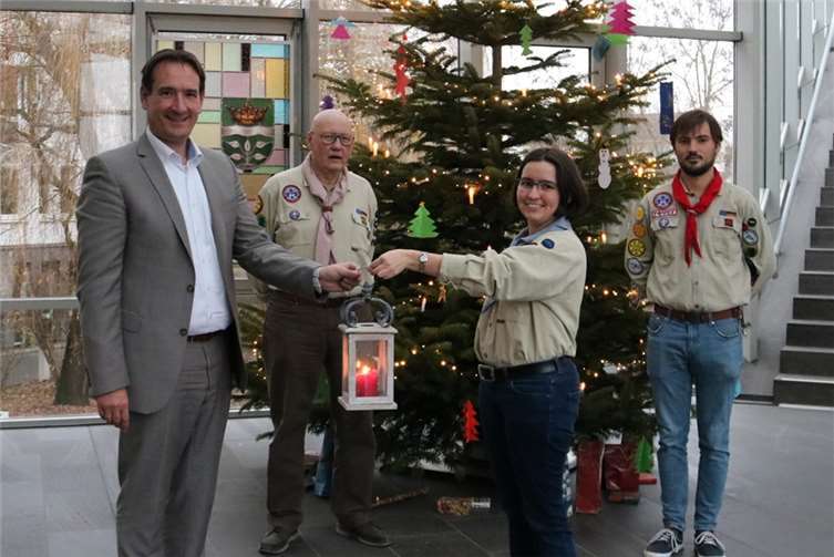 Martina, Christoph (re.) und Karl-Hermann Hennecke (2.v.li.) vom Pfadfinderstamm Kaltenengers überreichten dem Bürgermeister der Verbandsgemeinde Weißenthurm, Thomas Przybylla, (li.) das Friedenslicht 2021. Foto: VG Weißenthurm/Demleitner