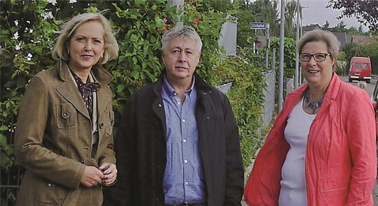 Martina Meyer (v.l.) und Hans Jürgen Hammelmann von der RWE mit der Beigeordneten Petra Kalkbrenner an einer Straßenlampe vor dem Kindergarten im Birkenweg in Swisttal-Buschhoven.Gemeinde Swisttal