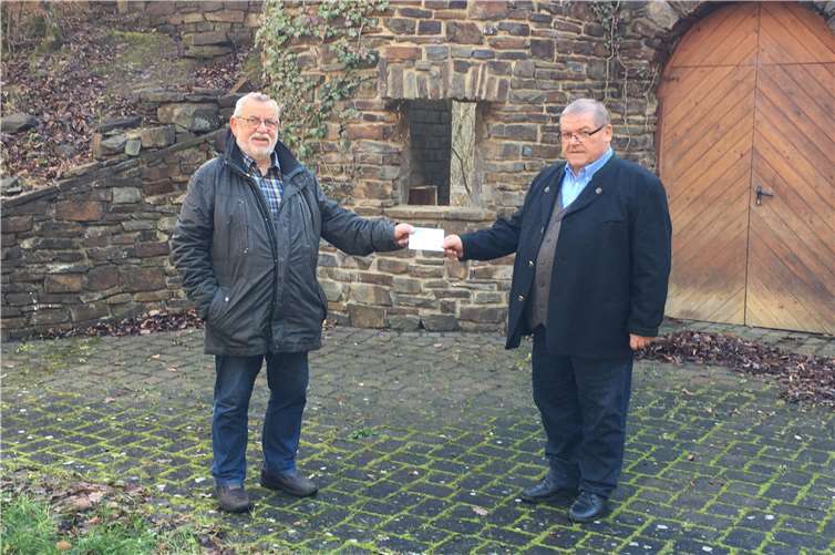Mathias Kircher überreicht vor der Kulisse der Freilichtbühne dem 2. Vors. des Fördervereins , Udo Stratmann, den Spendenscheck Die auf dem Bild abgebildten Personen sind mit der Veröffentlichung einverstanden. Foto: Antonia Kircher-Spindler