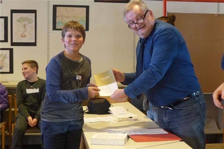 Mathis Hellinger erhält seine verdiente Siegerurkunde aus den Händen des Lehrers.Privat