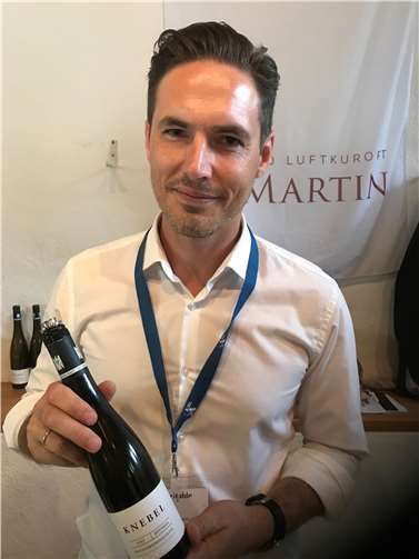 Matthias Knebel vom 1.7.2019 mit einer Flasche seines 100-Punkte-Weines. Foto: Moselwein e.V./Ansgar Schmitz