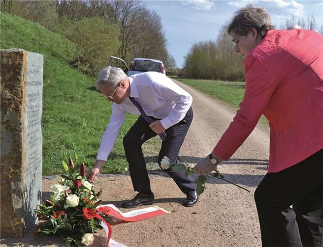 MdB Norbert Röttgen und Swisttals Beigeordnete Petra Kalkbrenner legen weiße Rosen nieder.