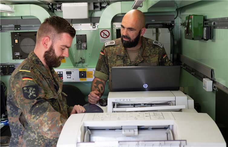 Medienfachkräfte des Zentrum Operative Kommunikation drucken Karten der Katastrophenregion.