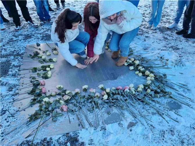 Melissa Aydemir, Sara Mehmeti und Nele Kaufmann (9d) an der auf Körpertemperatur erwärmten Gedenktafel für die Opfer aus Buchenwald.  Foto: Anna Streidenberger