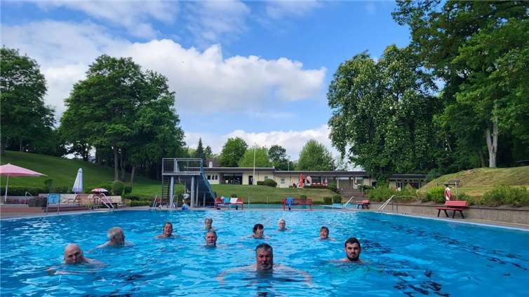 Mendigs Stadtbürgermeister Achim Grün (Mitte) und Badbetriebsleiter Lukas Mohr (rechts) eröffneten zusammen mit den ersten Badegästen die Freibadsaison.  Foto: David Geisbüsch