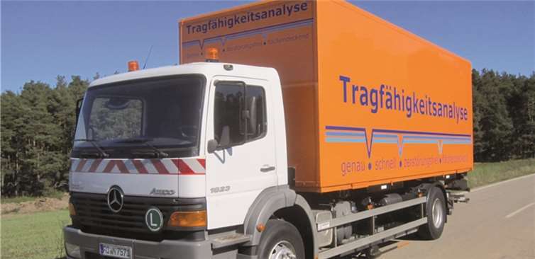 Messfahrzeug zur Tragfähigkeitsanalyse. Auf die Straßenoberfläche abgelegte Messarme erfassen während der Fahrt die Einsenkung der Straßenoberfläche unter den belasteten Hinterrädern. 600 Messpunkte werden pro Kilometer erfasst.TÜV Rheinland