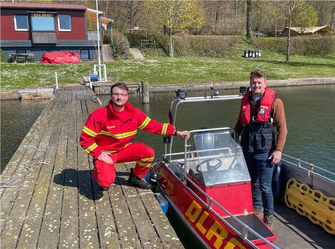 Mike Duffy, 2. Vorsitzender der DLRG Mendig, mit Stefan Oligschläger (re.) von der Verbandsgemeinde Brohltal auf dem erneuerungsbedürftigen Steg bzw. im Boot, dem größten Kostenposten der Wachstation am Laacher See, den die DLRG aus eigenen Mitteln finanzieren muss. Foto: privat