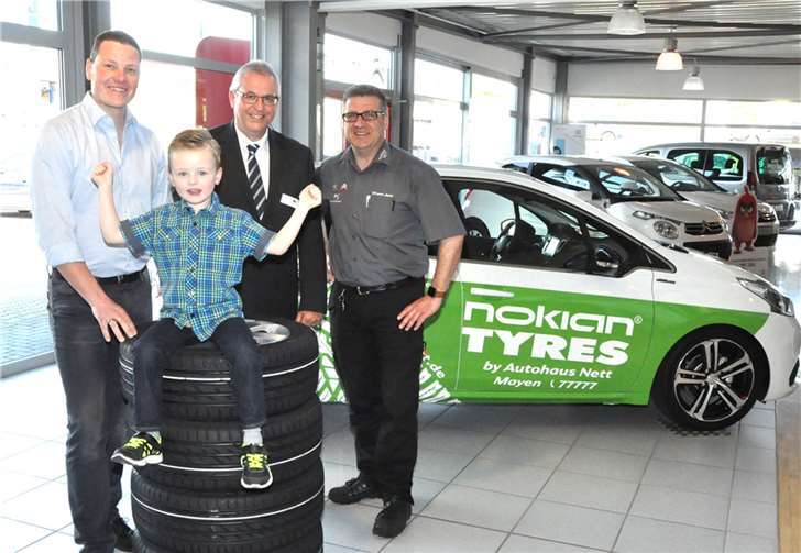 Mike Flinsch und Sohn Mika (l.) freuten sich über den Hauptgewinn, einen Satz Reifen von Nokian. Jürgen Nett (r.) vom Autohaus Nett und der Nokian-Repräsentant gratulierten herzlich. B.Schmitz