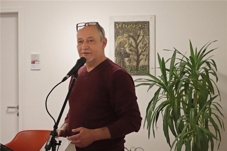 Mikele Voss erläutert den Besuchern der Vernissage die Entstehungsgeschichten seiner Fotoarbeiten. 