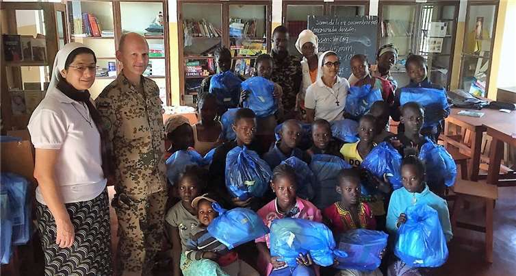Militärpfarrer Gundolf Brosig (in Uniform) und zwei Nonnen mit den beschenkten Müttern und Kindern.
