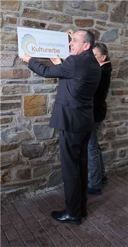 Minister Konrad Wolf und die ehemalige Museumsleiterin Monika Gass befestigten die Fliese mit dem Logo des Immateriellen Kulturerbes an der Außenwand des Keramikmuseums.