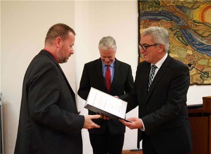 Minister Roger Lewentz (rechts) überreichte die Urkunde an Achim Hopfenmüller.