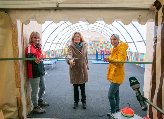 Ministerpräsidentin Malu Dreyer (Mitte) schnitt bei ihrem Besuch gemeinsam mit Sabine Schenke (links) und Nadine Wenigmann (rechts) vom TuS Ahrweiler das Band zur Eröffnung der provisorischen Turnhalle auf dem Gelände des Vereins „Die AHRche“ durch. Foto: JOST