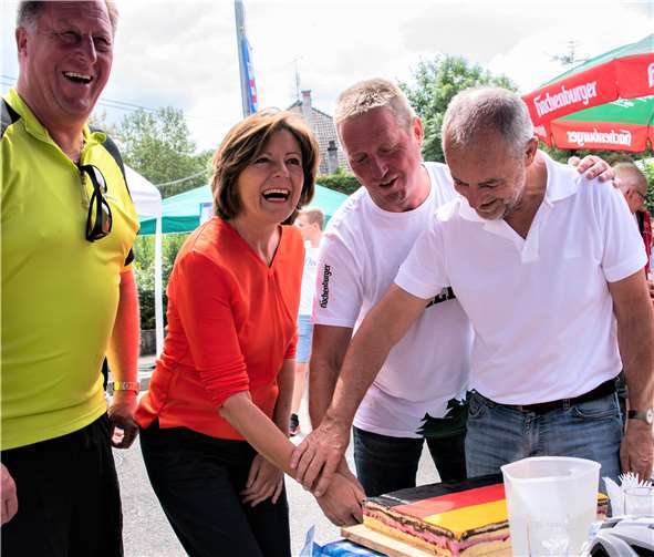 Ministerpräsidentin Malu Dreyer schnitt in Kausen die Deutschland-Torte an. VG-Bürgermeister Horst Rasbach (links) und Ortsvorsteher Detlev Roth (2. von rechts) assistierten. Eigentlich wäre die Fahrt für die Landeschefin hier geendet, doch sie entschloss sich spontan, bis Bendorf weiterzufahren. KER