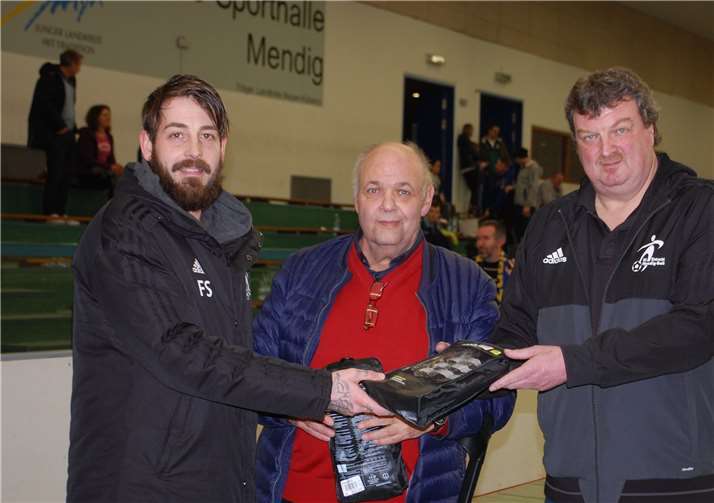 Mit 16 Treffern war Florian Schlich (links) der beste Torschütze des Turniers. Harald Heinemann, der Vorsitzende der SG Eintracht Mendig/Bell (rechts), überreichte ein Paar Schienbeinschoner.