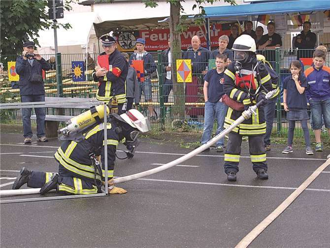 Mit Atemschutz und Lösch-Schlauch durch einen Tunnel.