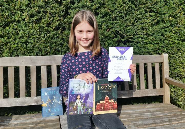 Mit Buchpreisen und Sieger-Urkunde: Lisa Schmitt hat den Vorlesewettbewerb gewonnen. Foto: Kreisverwaltung Ahrweiler / Kempenich