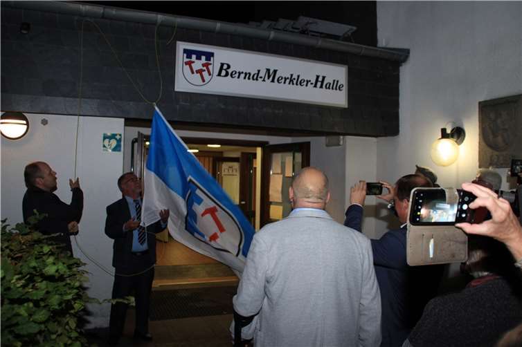 Mit Enthüllung des Namensschildes trägt die Gemeindehalle Bell nun den Namen Bernd-Merkler-Halle.