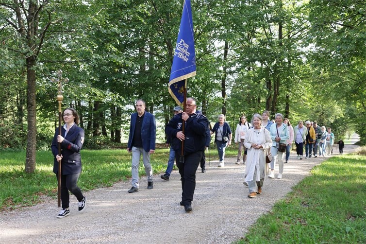 Mit Fahne der Freiwilligen Feuerwehr und Vortragekreuz pilgert die Gruppe zur Schutzengelkapelle