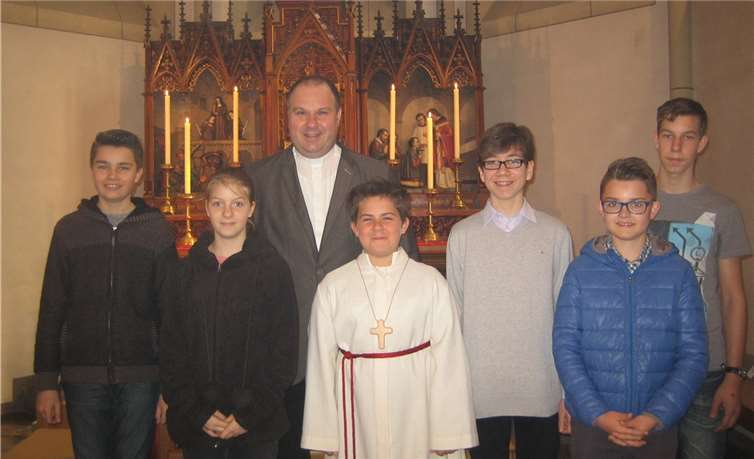 Mit Maurice (Mitte) freuen sich Pfarrer Schuh und die anderen Messdiener. Privat