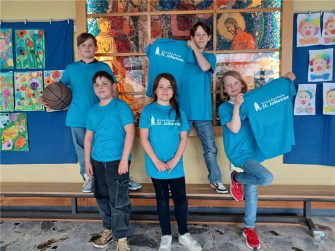 Mit Stolz und Freude präsentieren einige Schulkinder die neuen Trikots.