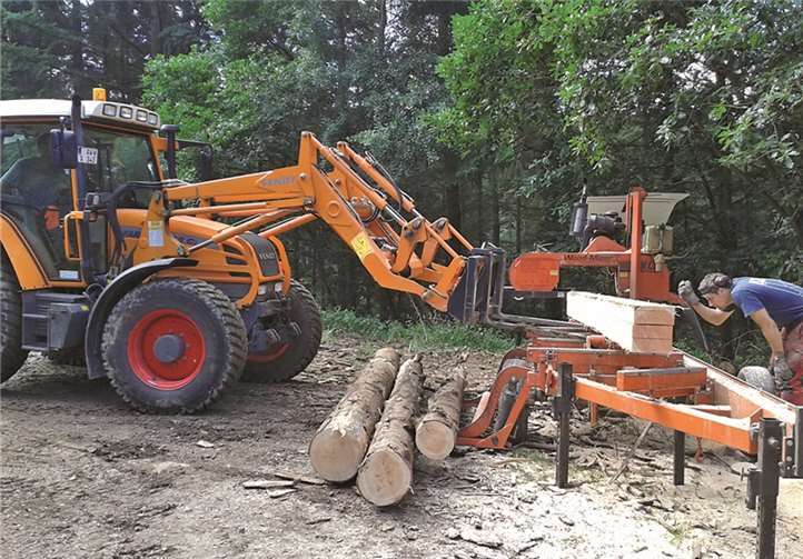 Mit dem Frontlader werden die veredelten Hölzer vom Sägetisch aufgenommen und auf einem Anhänger für den Abtransport abgeladen. Dietmar Ebi/Landesforsten RLP