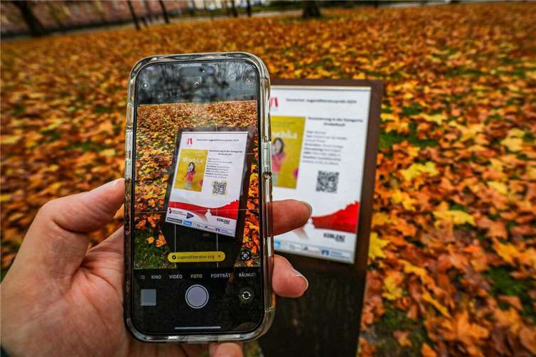 Mit dem Smartphone lässt sich der Koblenzer Literaturpfad am Clemensplatz erkunden. Seit Kurzem sind dort die Nominierungen für den Deutschen Jugendliteraturpreis 2024 zu finden.  Foto: Stadt Koblenz/Andreas Egenolf