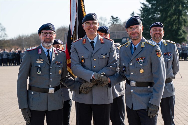 Mit dem symbolischen Handschlag besiegelt Generalmajor Kuhn (mi) die Übergabe des Kommandos für das ZOpKomBw von Oberst Dr. Akaltin (li) auf Oberst Böttger (re).