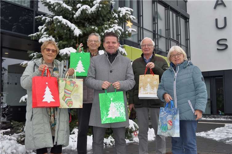 Mit den Geschenktüten vor dem Weihnachtsbaum am Rathaus, von links: Marlies Maruschke (Präsidentin Lions Club Bonn-Rhenobacum), Manfred Weizbauer (Schatzmeister Lions Club-Hilfswerk), Bürgermeister Holger Jung, Joachim Krüger (Mitglied Activity Ausschuss Lions Club Bonn-Rhenobacum) und die städtische Demografiebeauftragte Bettina Hihn.Foto: Stadt Meckenheim