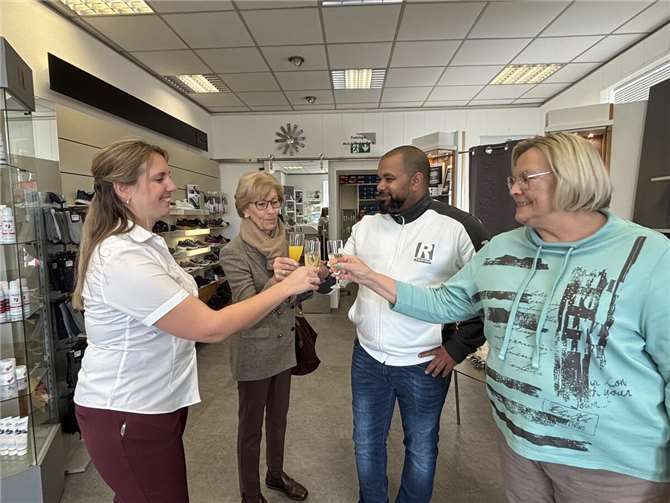 Mit den treuen Kunden wird bei einem Glas Sekt auf den Neubau angestoßen.