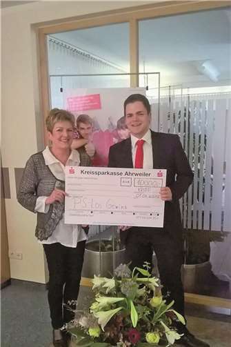 Mit einem Blumenstrauß und dem symbolischen Scheck über 10.000 Euro gratulierte Niklas Bell, Leiter der Geschäftsstelle in Kripp, Gisela Gronemeier zu ihrem Hauptgewinn. KSK
