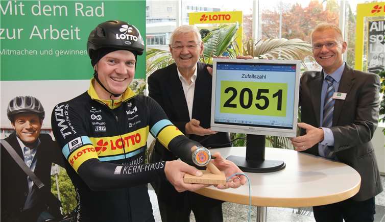 Mit einer Fahrradglocke stoppte Radprofi Tobias Knaup den Zufallsgenerator und bestimmte so die 169 Gewinner der AOK/ADFC-Aktion. AOK-Projektmanager Rolf Geifes (re.) und ADFC-Vertreter Jo Schaefer übersetzen die Zahlen in Namen. AOK/Olaf Schepers