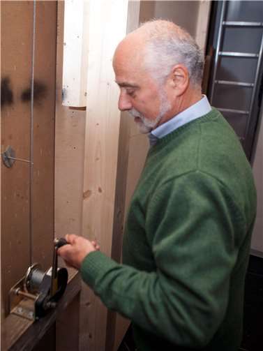 Mit einer Kurbel lässt Hans-Werner Kühlwetter das Gemälde herab und gibt so die Muttergottes dahinter frei.