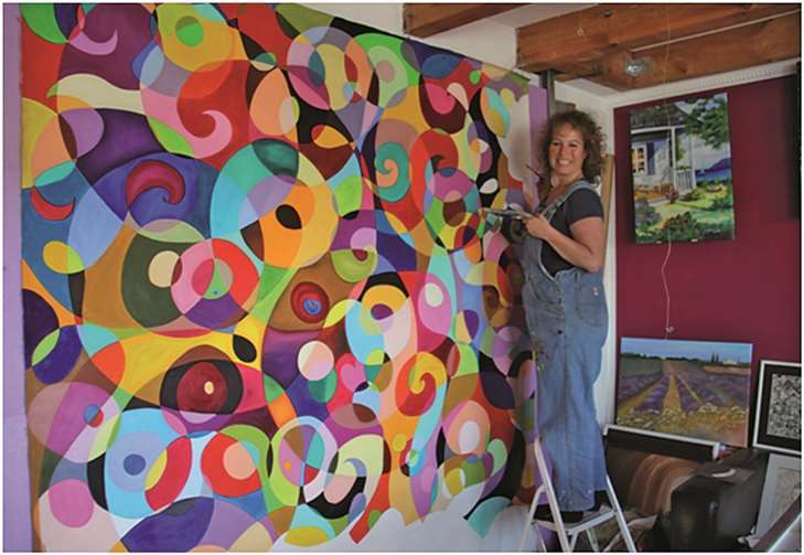 Mit einer Trittleiter ausgestattet malt Marion Gemmer das große farbenfrohe Ölbild. privat