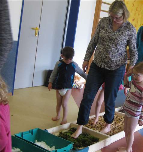 Mit hochgekrempelten Hosenbeinen wurden die Mütter und Väter von ihren Kindern durch den Fußparcours geführt.