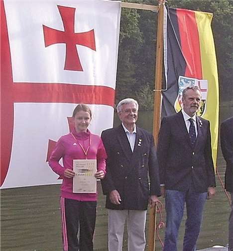 Mit ihrem überzeugenden Sieg im Einer der Mädchen U14 war Julia Bischof (l.) die jüngste Titelträgerin der RG Treis-Karden. Zu den Gratulanten auf dem „Siegersteg“ gehörten der Ehren-Vorsitzende des Ruderverband Rheinland Reiner Freund (Mitte) und der Vorsitzende des Landesruderverbands Rheinland-Pfalz Ulrich Steinfurth (r.). Privat
