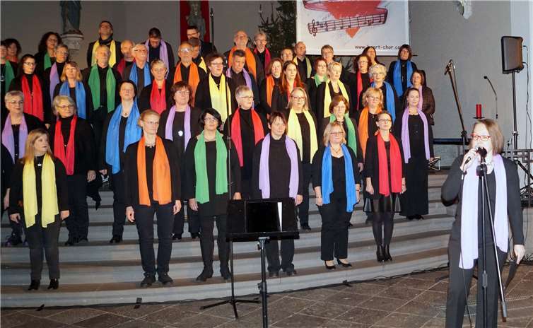 Mit ihren bunten Tüchern und viel Musikalität sorgte der Heart-Chor in Treis für Farbe. Annette Frick (rechts) stellte die Formation aus dem Hunsrück kurz vor. TT