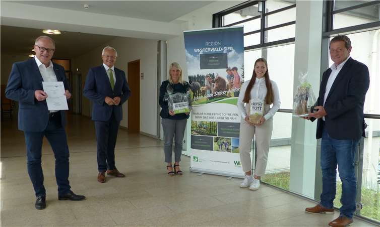 Mit kleinen Geschenken aus der Region Westerwald honorierten die Landräte der drei Landkreise gemeinsam mit dem Vorstand der Wir Westerwälder gAöR die Arbeit von Lorena Schwientek (v.l.n.r.): Dr. Peter Endres, Landrat Altenkirchen; Achim Hallerbach, Landrat Neuwied; Sandra Köster, Vorständin Wir Westerwälder; Lorena Schwientek; Achim Schwickert, Landrat Westerwald.Foto: Wir Westerwälder
