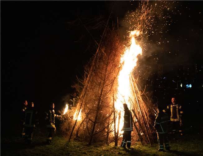 Mit vereinten Kräften sorgten die Helfer der Freiwilligen Feuerwehr für ein meterhohes Martinsfeuer.