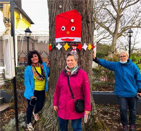 Mitglieder von „Wir für Lahnstein“ vor einem der dekorierten Bäume. Foto: Erika Labonte