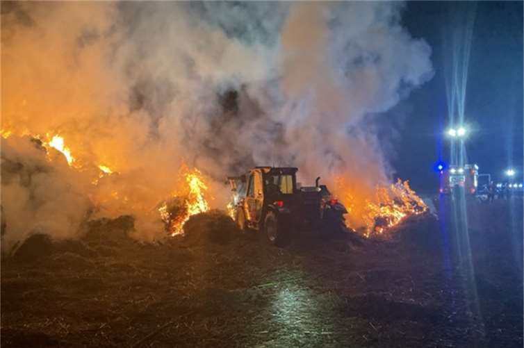 Mithilfe eines Teleskopladers wurden etwa 30 Rundballen aus der Strohmiete entfernt.  Fotos: Feuerwehr und Rettungsdienst Bonn